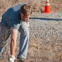 A volunteer pulling up weeds by hand.